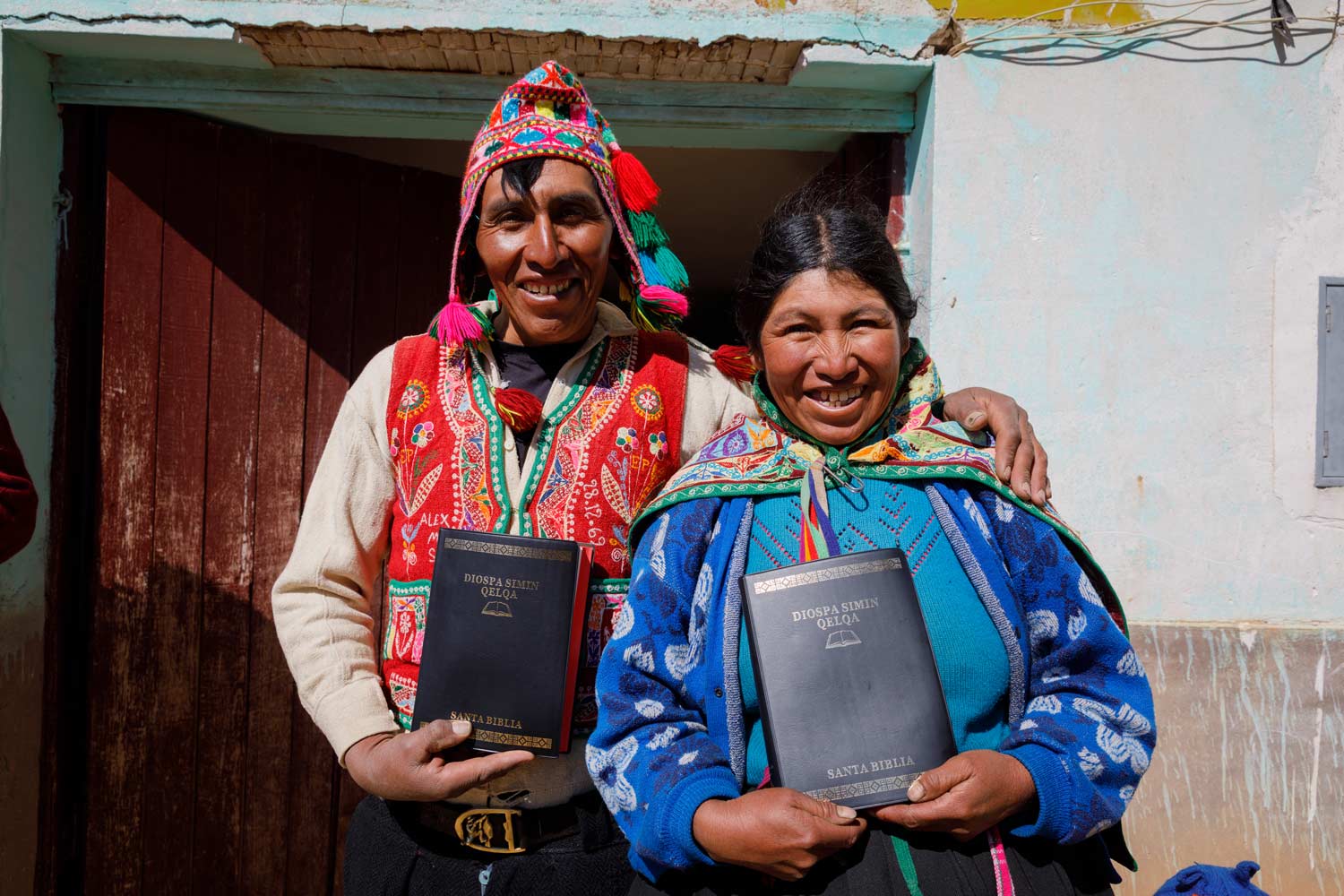 Peru smiling man and woman holding up their new Bibles